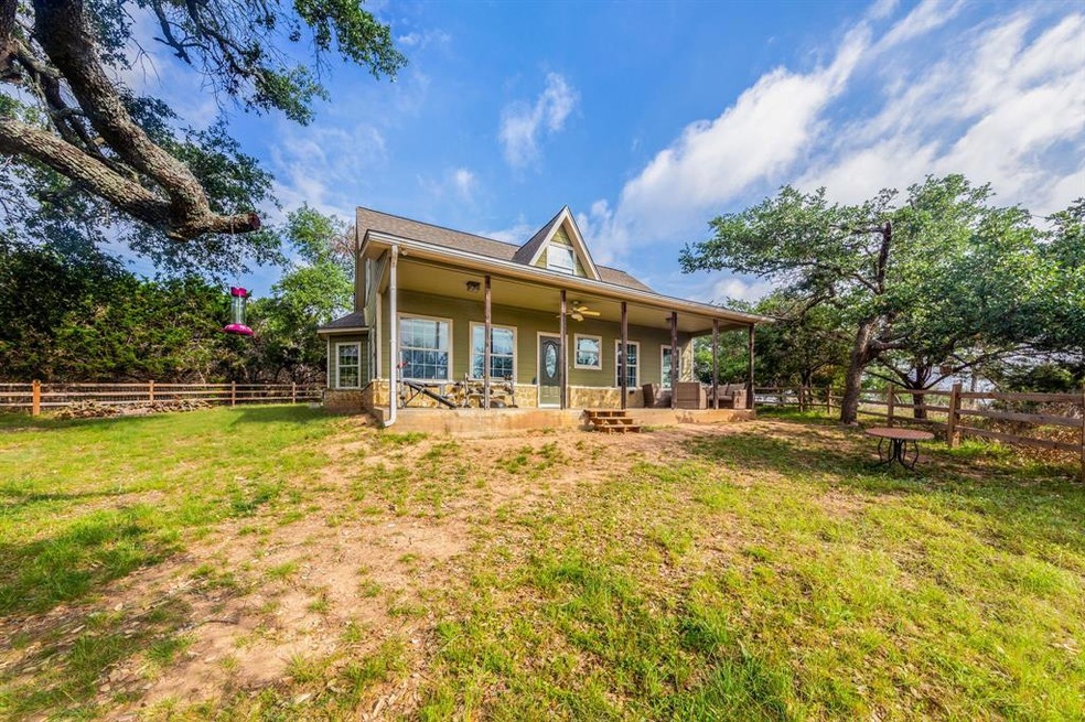 Nestled on 1.5 acres, this home offers privacy, gorgeous oak trees, a covered porch to unwind, a fenced in yard for your pets and approximately 2400 sq ft of warehouse space.