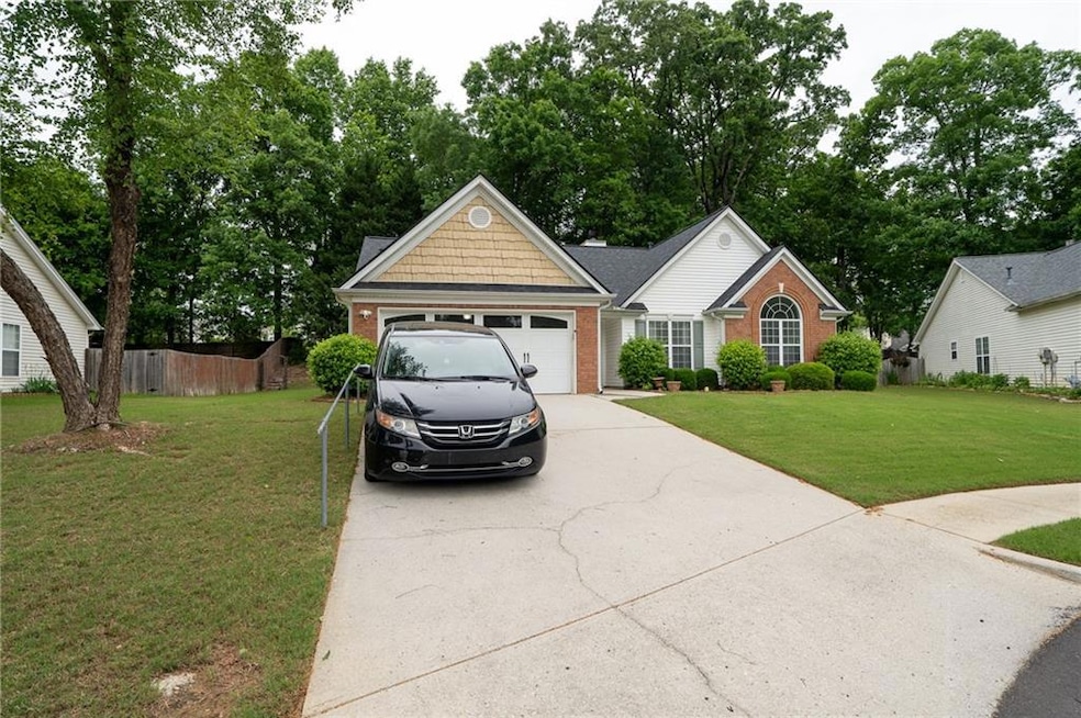 Single story home with brick siding, concrete driveway, and a garage