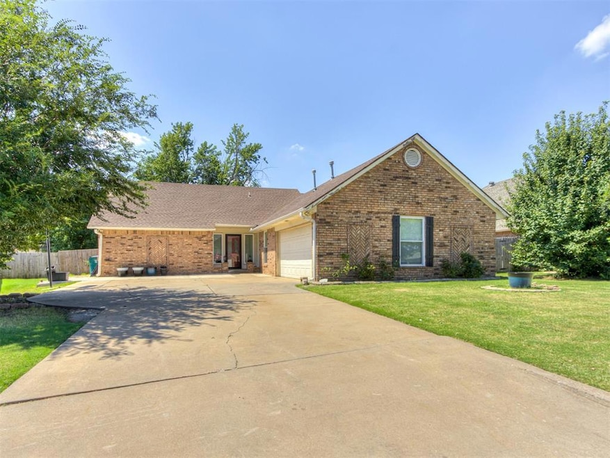 View of front of property with a garage, driveway, brick siding, and a shingled roof