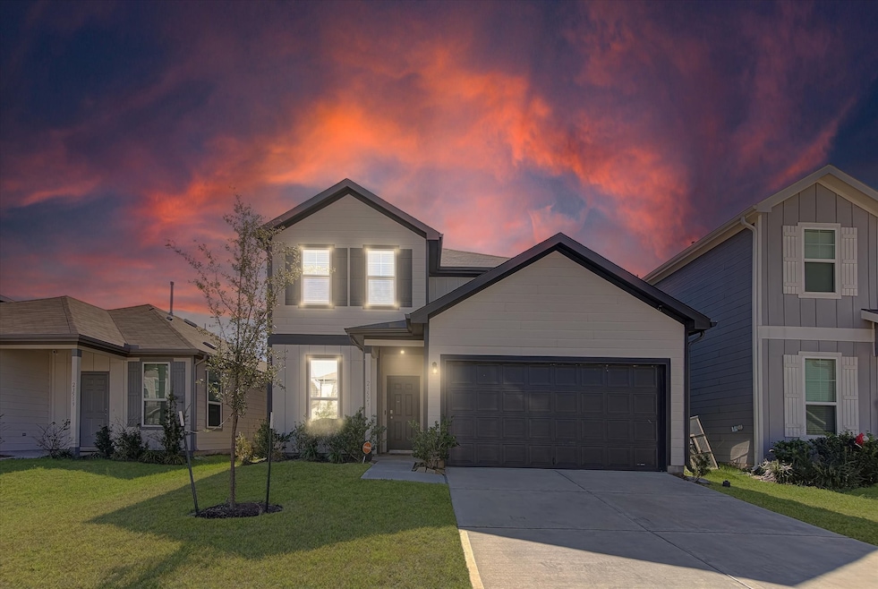 This home features a modern exterior with a double garage, set against a stunning sunset backdrop. It offers a well-maintained lawn and a welcoming entrance, ideal for comfortable living.