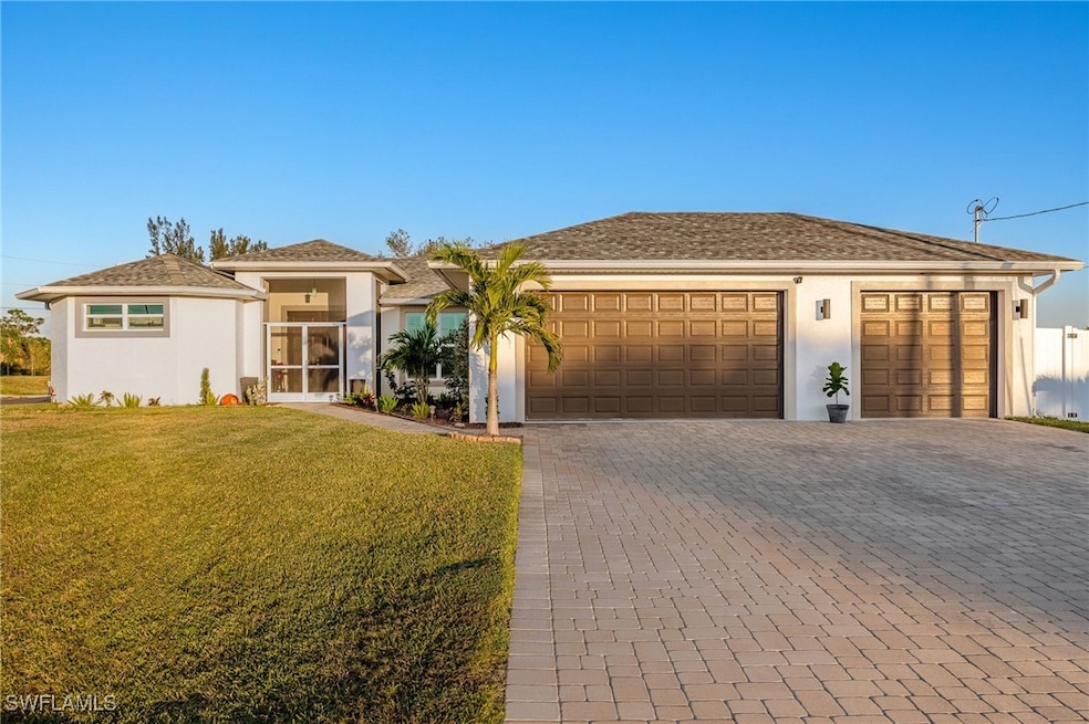 View of front of home with a front lawn and a gara
