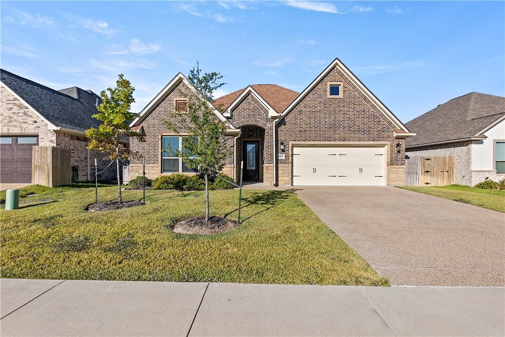 View of front facade with concrete driveway, brick siding, and a garage