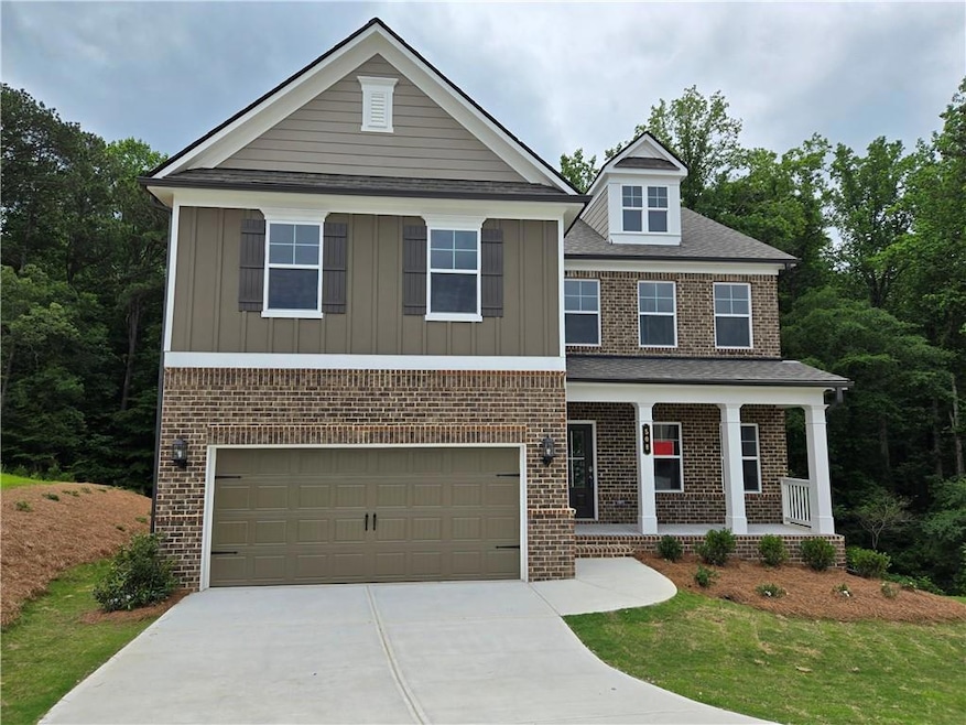View of front of house with a porch, concrete driveway, brick siding, and a garage