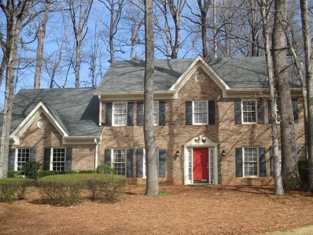 Colonial inspired home with brick siding