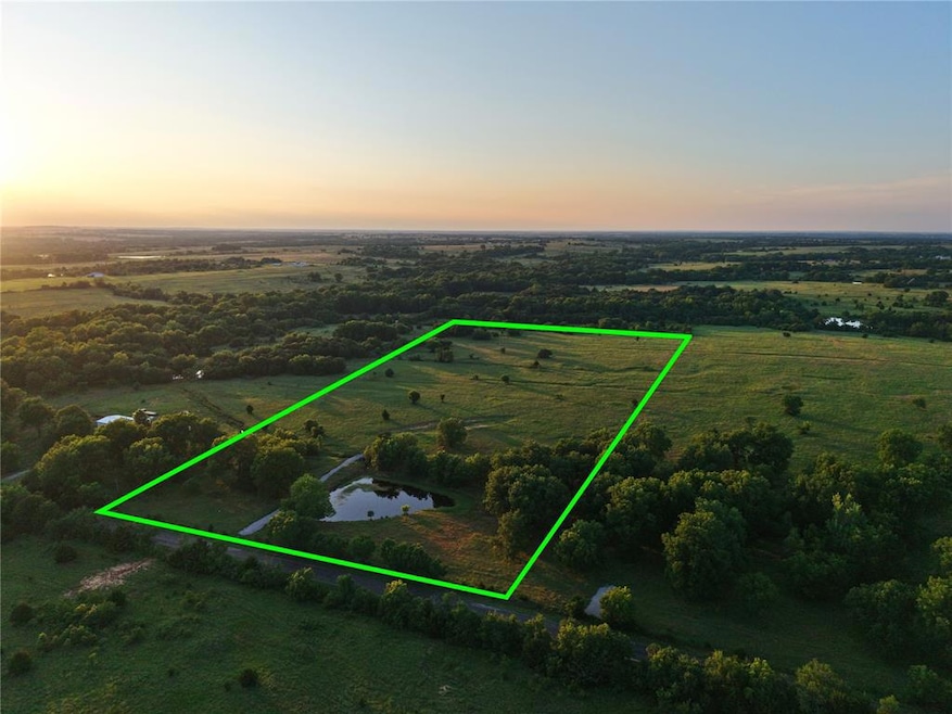 Aerial view of sparsely populated area featuring property parcel outlined and a nearby body of water