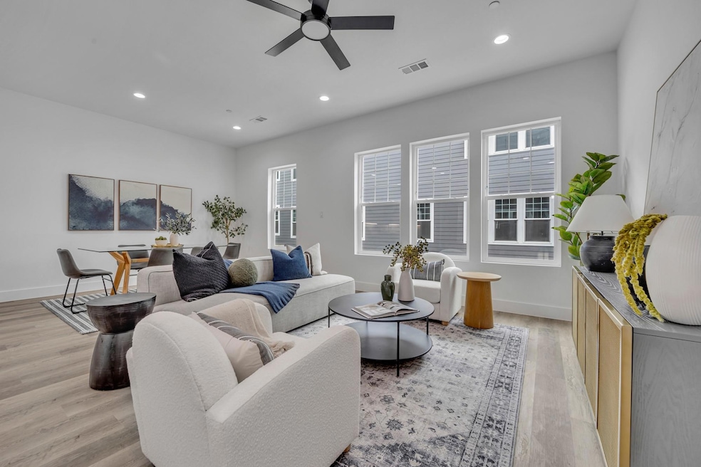 Living area with ceiling fan, visible vents, a hea