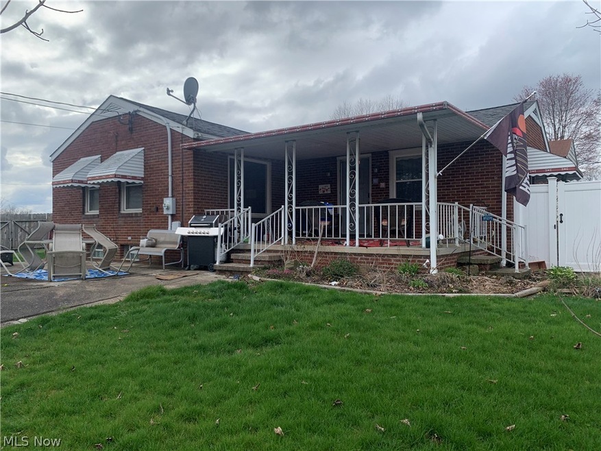 Rear view of property with a porch and a yard