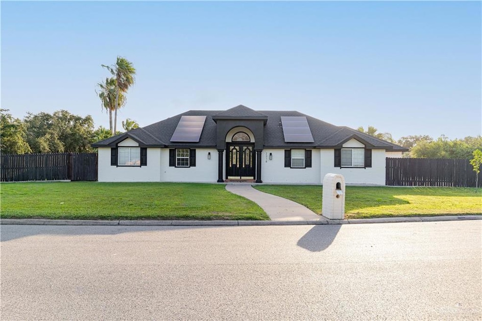 View of front of home with roof mounted solar panels and roof with shingles