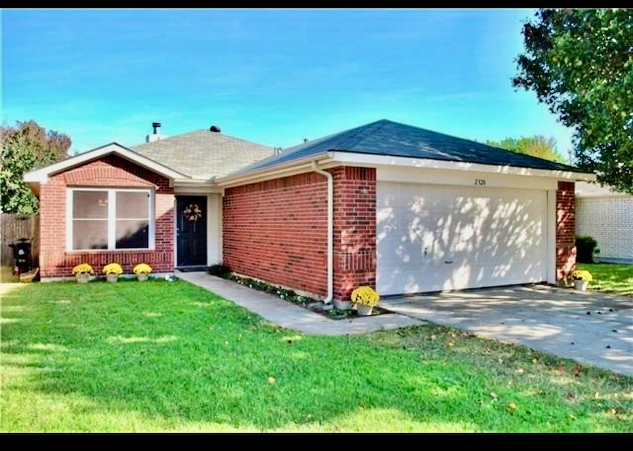 Ranch-style house featuring brick siding, driveway, and a garage