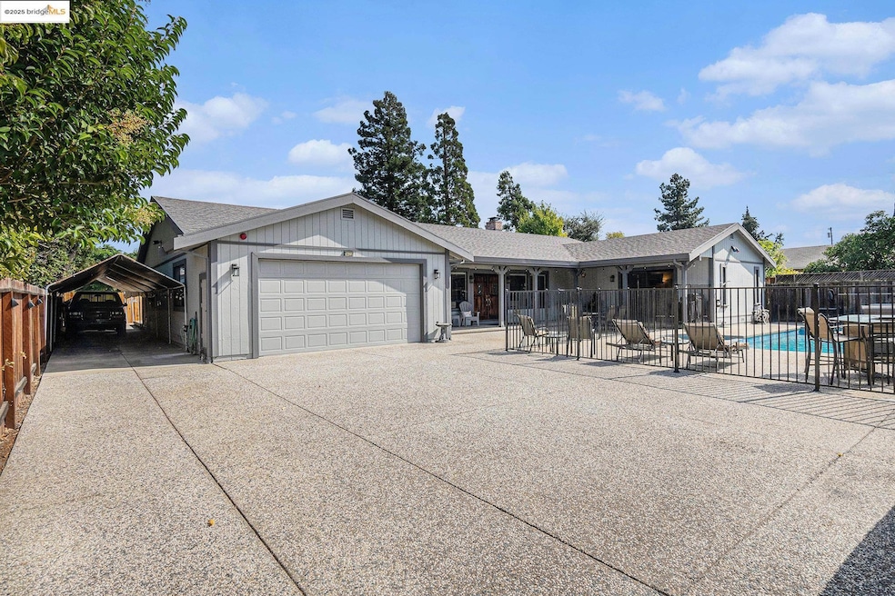 Ranch-style house with a patio, driveway, an attached garage, and a carport