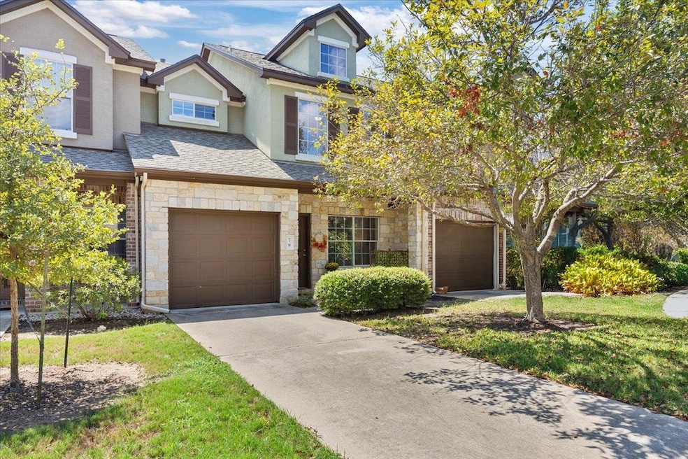 View of front facade featuring stone siding, a shingled roof, concrete driveway, stucco siding, and an attached garage