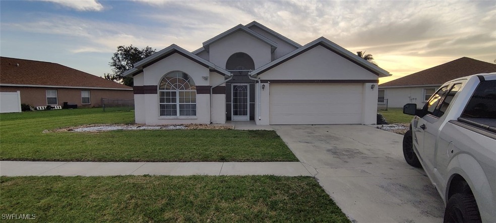 Single story home with a garage and a lawn