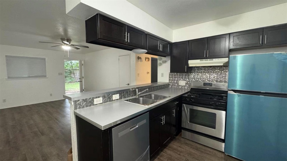 Kitchen with a sink, decorative backsplash, stain