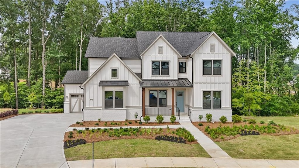 Modern house with covered porch, roof with shingles, a standing seam roof, driveway, and board and batten siding
