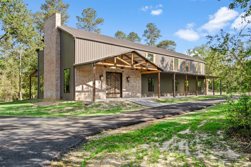 Property is surrounded by trees providing extra privacy. Circular asphalt driveway runs in the front of the home.