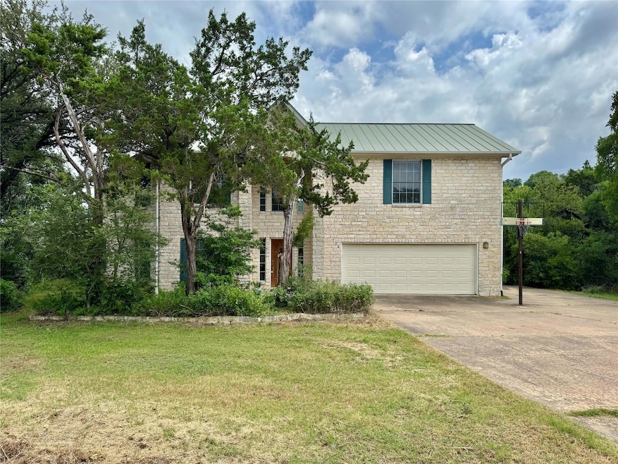 View of front of house with a garage, stone sidin
