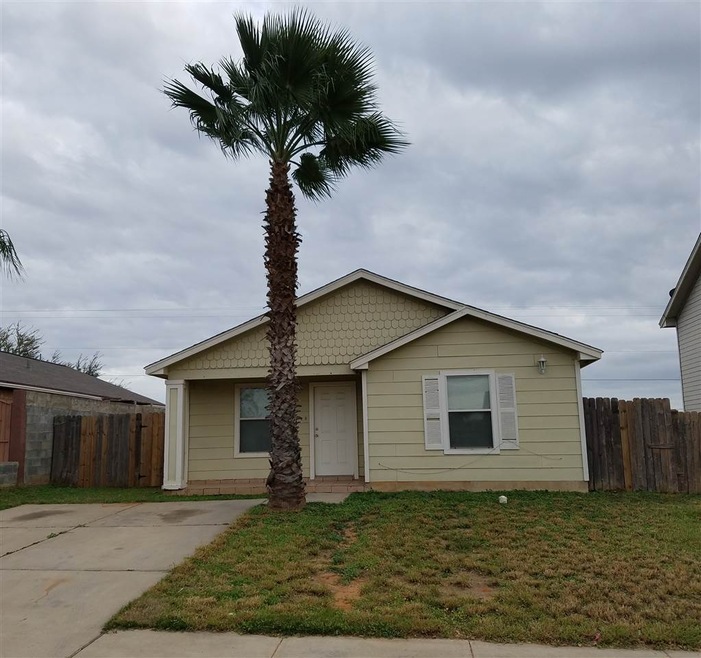 Front of house with large driveway.