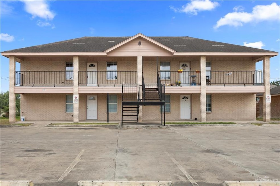 View of building exterior featuring uncovered parking