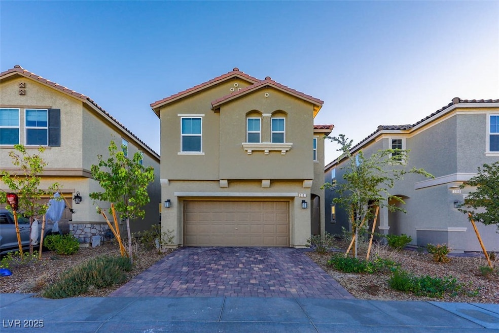 Mediterranean / spanish-style home featuring stucco siding, an attached garage, and decorative driveway