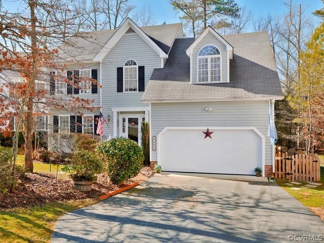 Front of home features mature landscaping.  House