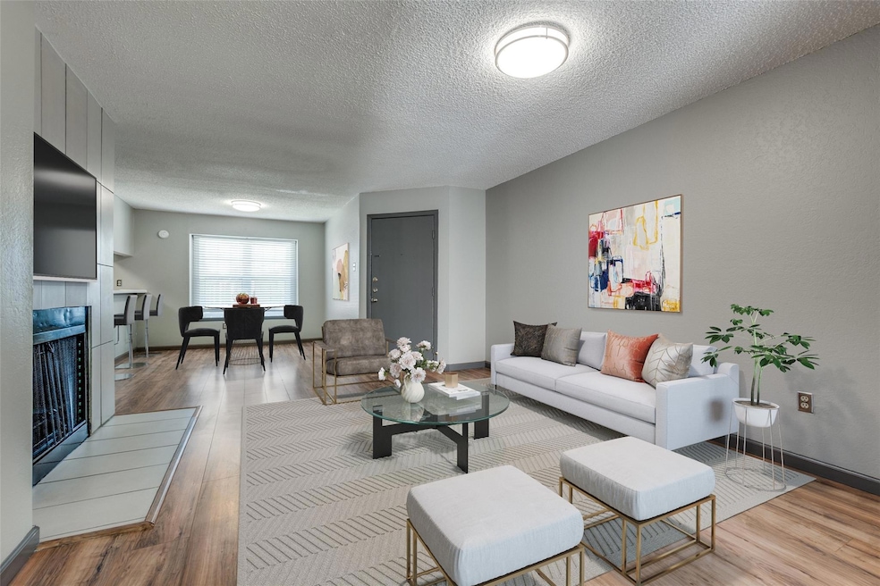 Living room with wood finished floors, a textured 