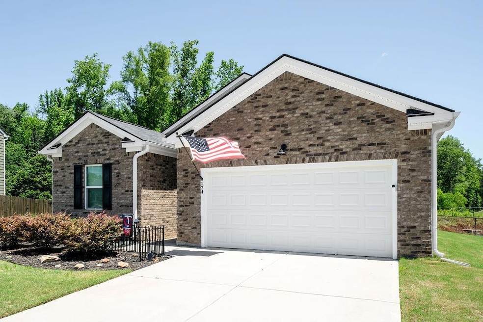 Ranch-style house featuring concrete driveway, a garage, and brick siding