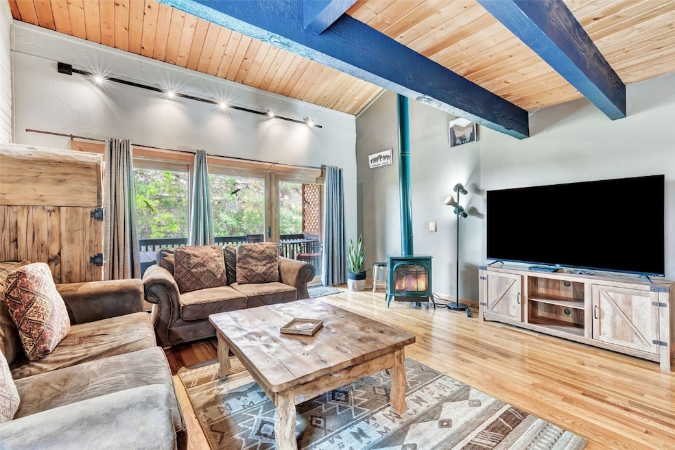 Living room featuring wood ceiling, a wood stove,