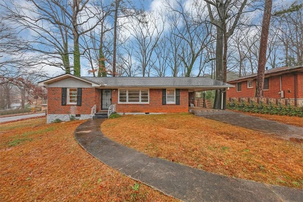 Ranch-style home featuring brick siding, asphalt driveway, a front yard, a carport, and entry steps