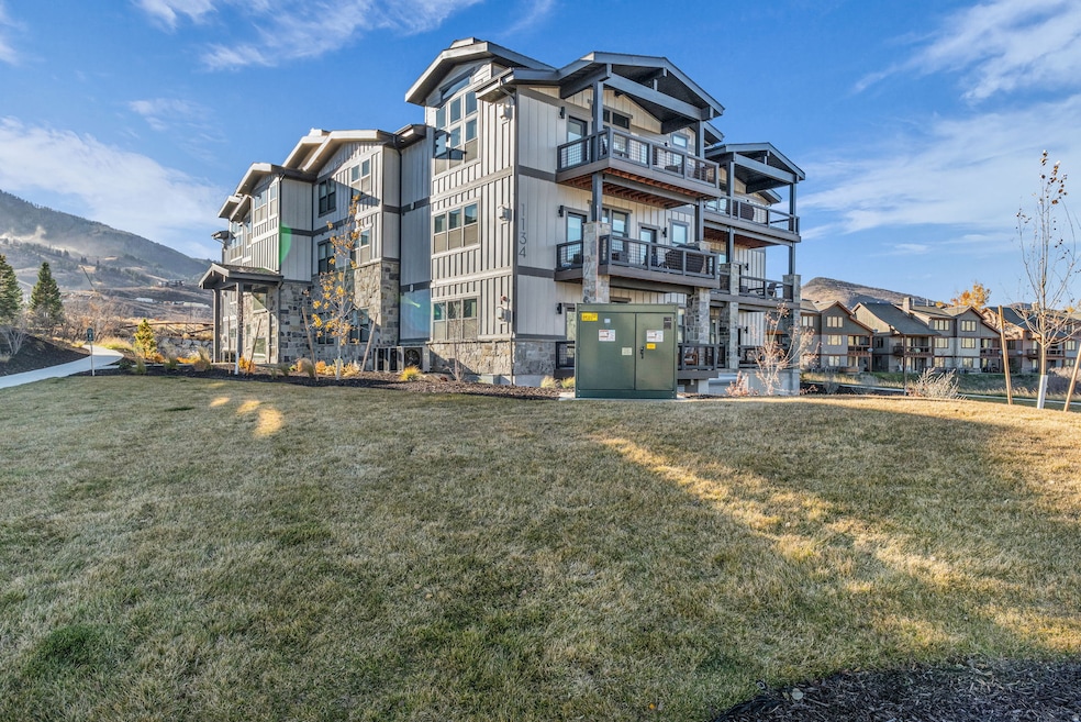 View of side of property featuring a balcony and stone siding