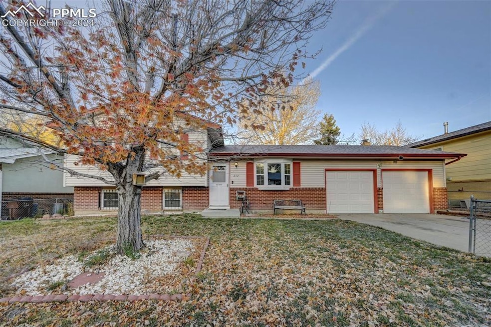 Tri-level home featuring a front lawn and a garage