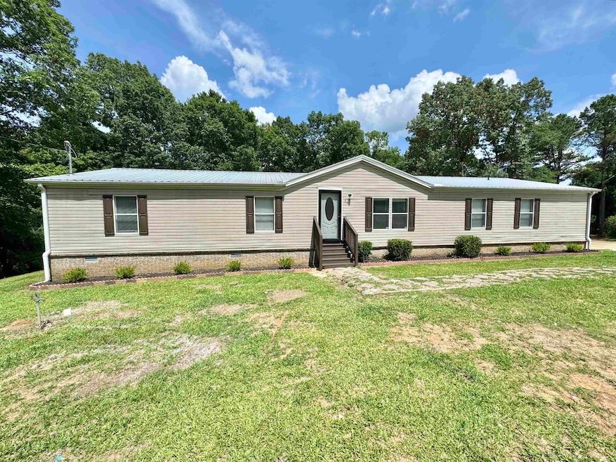 Manufactured / mobile home with crawl space, entry steps, a front lawn, and a metal roof