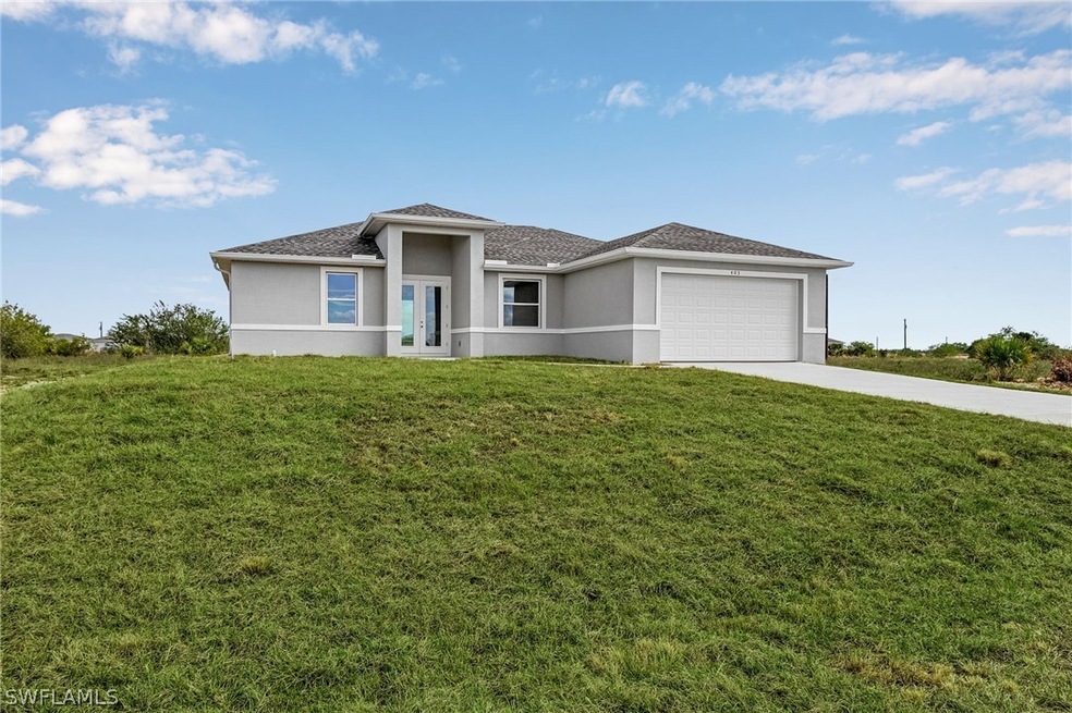 View of front of home with a garage and a front ya