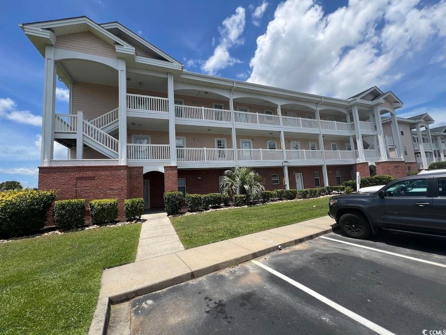 View of building exterior featuring uncovered parking