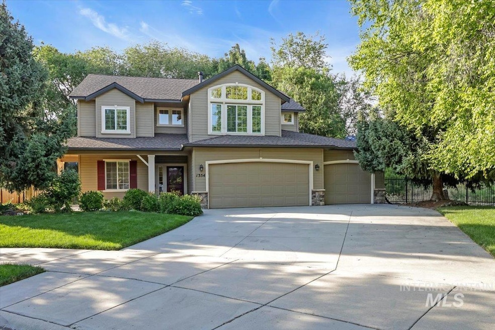 View of front facade with driveway, a garage, stone siding, and a shingled roof