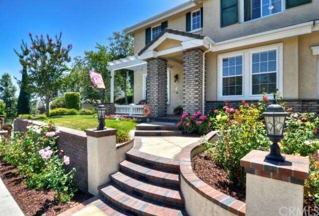 Elegant entry with flower beds and custom hardscap