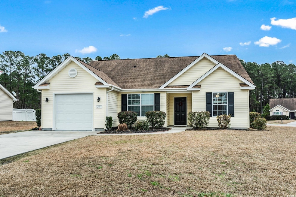 Single story home featuring a garage and a front y