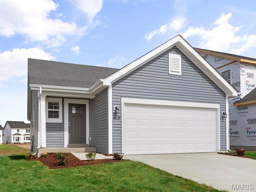 View of front facade with driveway, a garage, and a front lawn