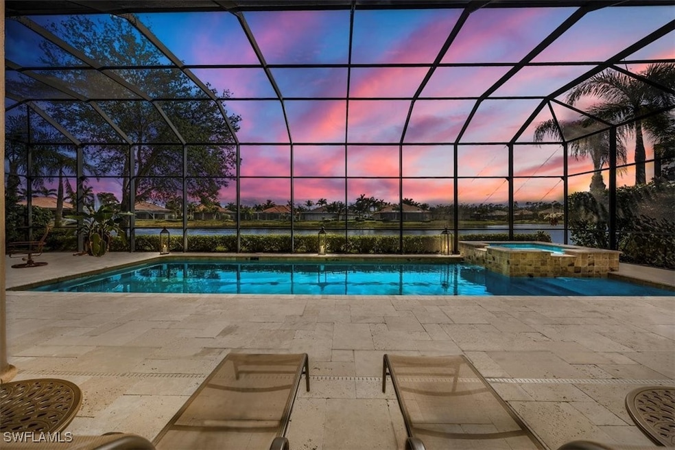 Pool at dusk featuring a lanai, a water view, a pa