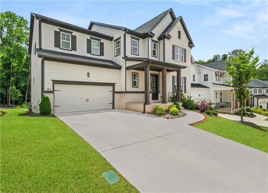 View of front of property with a porch, driveway, a garage, a front yard, and brick siding