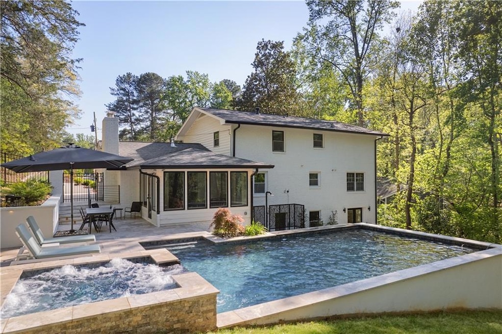 Rear view of house with a patio area, a sunroom, a