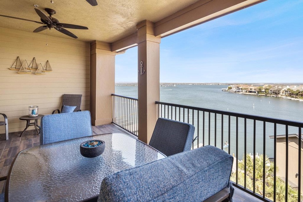 Balcony featuring a ceiling fan, outdoor dining space, and a water view
