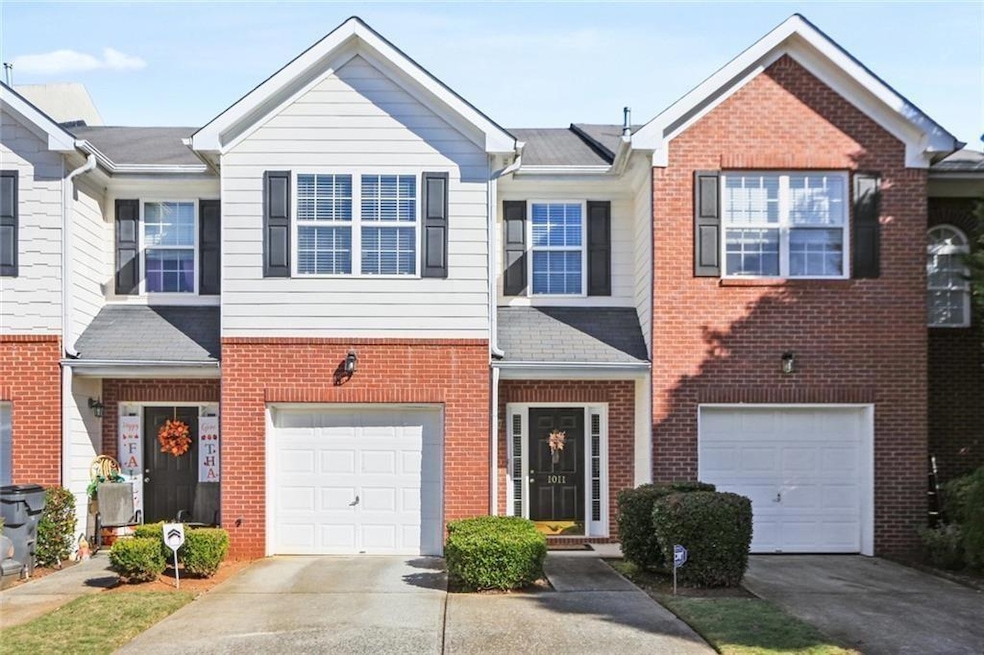 View of property featuring an attached garage, driveway, and brick siding