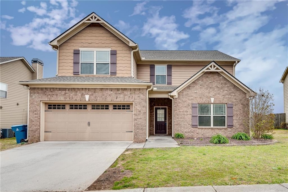Craftsman-style house featuring an attached garage, a front lawn, concrete driveway, brick siding, and a shingled roof