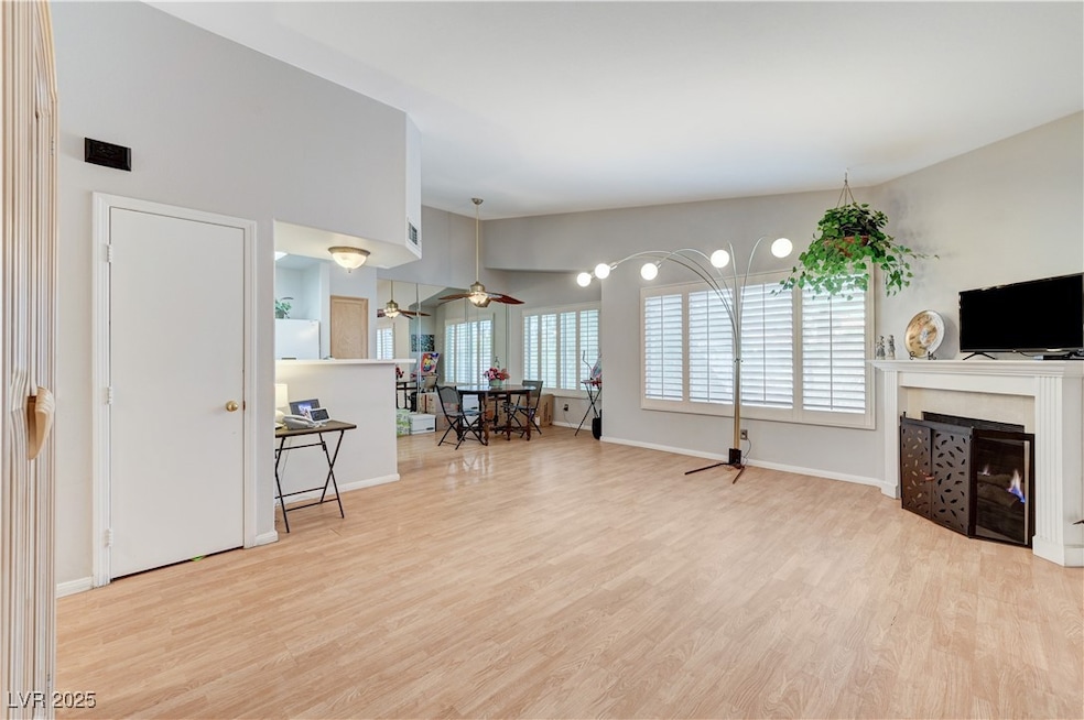 Living room with wood finished floors, a fireplace
