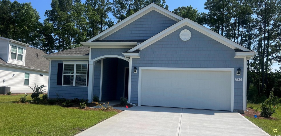 View of front of property with a front yard, a gar