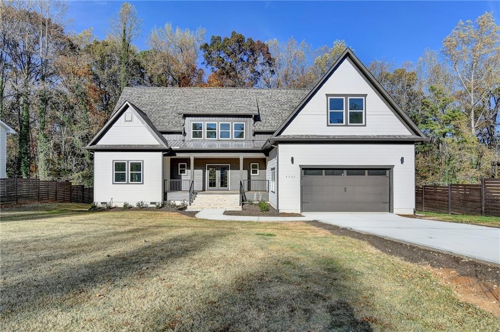 Modern farmhouse style home featuring a porch, concrete driveway, a shingled roof, and a garage
