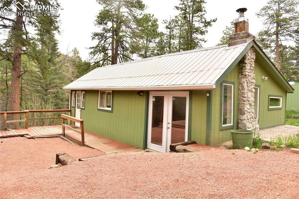 Back of property featuring french doors, a chimney, a wooden deck, and metal roof