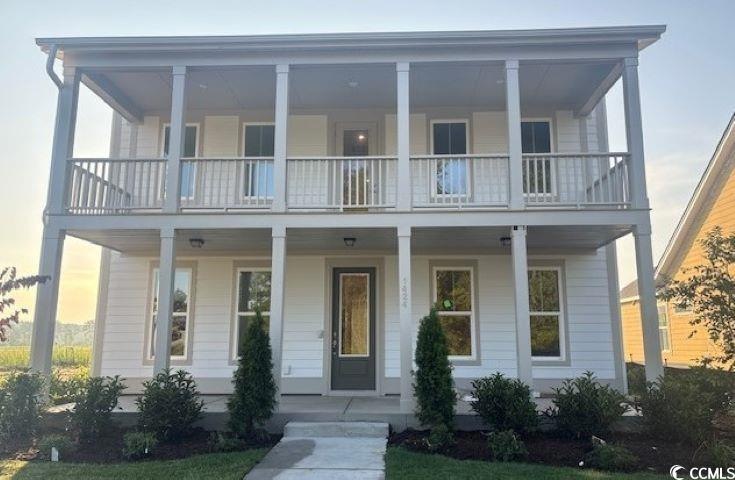 View of front facade featuring a balcony and a porch