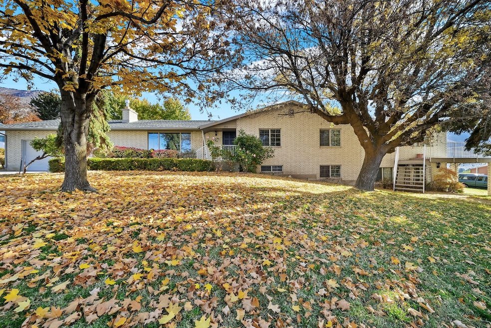 Ranch-style home featuring stairway, a chimney, and brick siding