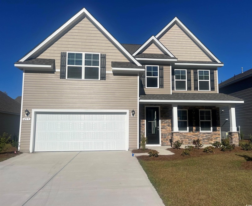 Craftsman house featuring a front yard and a garag